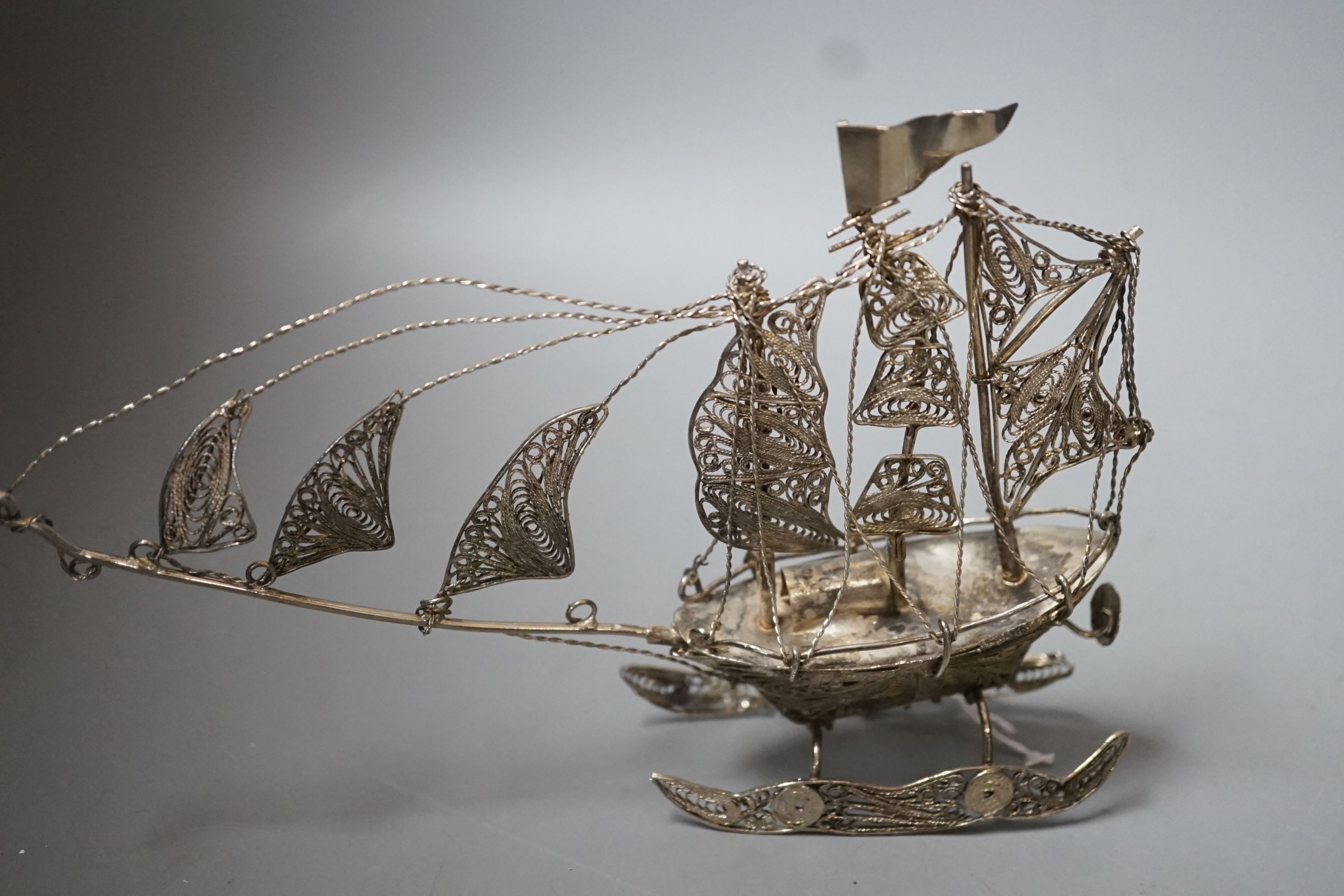 A Chinese filigree white metal model of a ship, length 19cm, a similar model of a rickshaw with driver and passenger and a similar oval box and cover